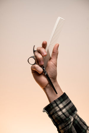 Barber shop. Barber or hairdresser male hand holding scissors and comb.の写真素材