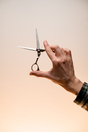 barber male hand accurate holding hairdresser scissors. Barber professional tools.の写真素材