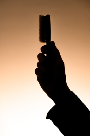 dark silhouette of male hand holding barber fade brush for man. Side viewの写真素材