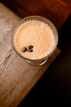 Top view of glass with foamy cocktail garnished with coffee beansの写真素材