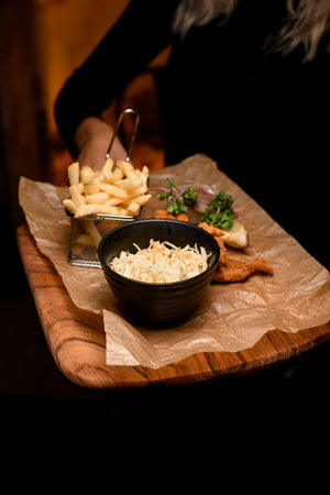 view of french fries and bowl of sauerkraut and delicious batter fried pork earsの写真素材