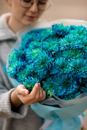 close-up of bouquet of blue chrysanthemums in hands of womanの写真素材