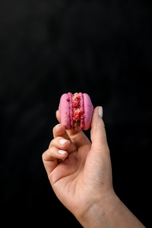 close-up of female hand neatly holds delicious sweet pink macaronの写真素材