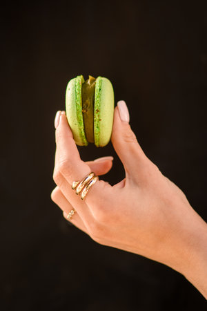 close-up of female hand neatly holds delicious sweet green macaronの写真素材