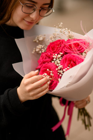 Closeup portrait of brown hair woman with bouquet of big red rosesの写真素材