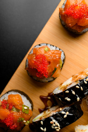 Assorted set of various rolls with salmon, tobiko calve, avocado wrapped in nori and decorated with sesameの写真素材