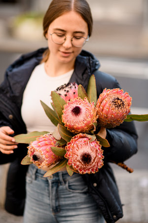 Young woman holding big beautiful blossoming bouquet of fresh Nutan Protea flowersの写真素材