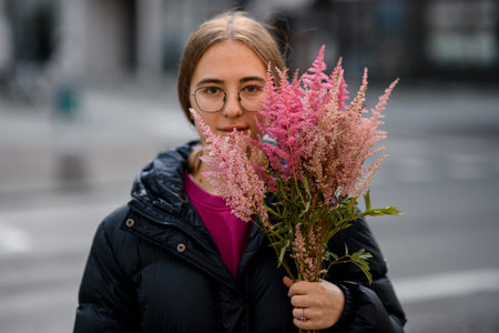 Smiling woman holds branches with bright colors heather plant in the handsの写真素材