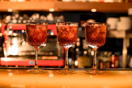 Red cocktails with ice cubes in old styled glasses on the bar counter in the barの写真素材