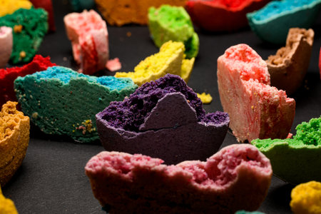 Variety of tasty different colors broken in half macaroons on black upside. Closeup viewの写真素材