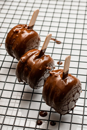 Tasty french desserts macarons covered with melted chocolate on metal mesh. Top view