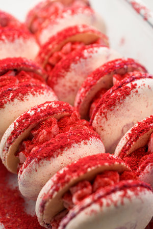 Closeup view on sweet pink French or Italian macarons sprinkled with red powder.の写真素材