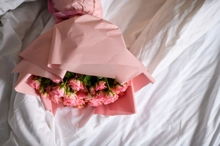 Beautiful wedding bouquet of fresh pink roses in pink wrapping paper on white backgroundの写真素材