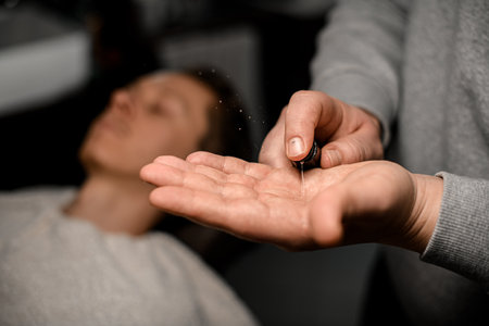 Barber applies moisturizing emulsion to his hand to massage clients face before shaving processの写真素材