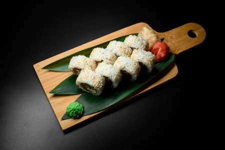 Top view of traditional delicious fresh sushi roll set with rice, cream cheese, avocado, salmon, sesame on black backgroundの写真素材