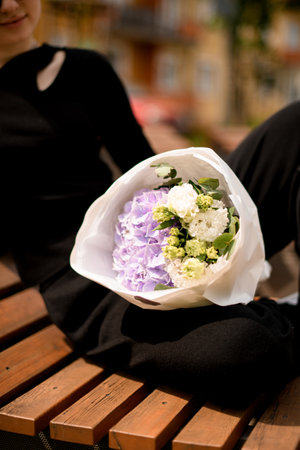 Selective focus on delicate mix of eustoma, hydrangea and carnations flowers in womans handの写真素材
