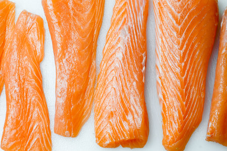 Fresh raw salmon filleted pieces isolated on white background, top viewの写真素材