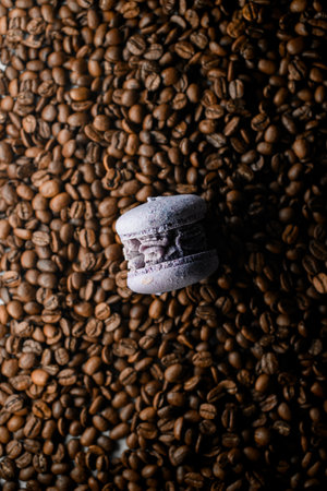 Top view on appetizing french or Italian blueberry macaron dessert on roasted coffee beans backgroundの写真素材