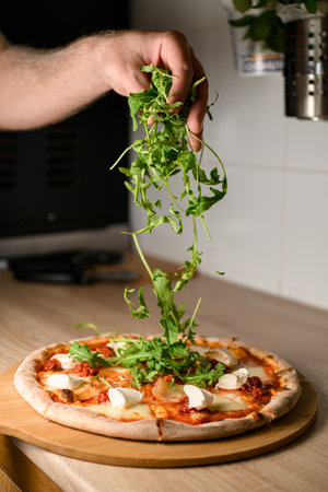Chefs touch. Arugula sprinkled on a finished pizzaの写真素材