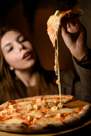 Savoring the first slice. Stretchy cheese pizza delightの写真素材