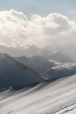 Beautiful mountain landscape, where snow-capped mountain ranges are shrouded in fog