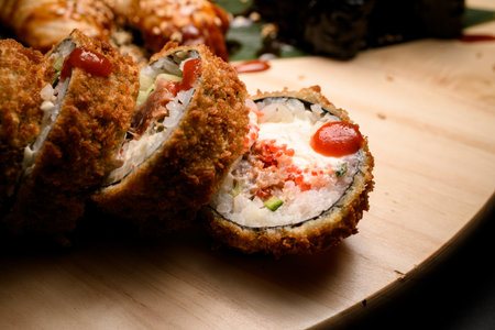 Close-up of pieces of fried sushi rolls filled with cucumber and cream cheese and fishの写真素材