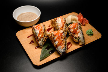 Sushi rolls sandwich tempura covered in brown sauce with wasabi and gingerの写真素材