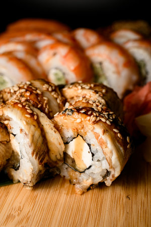 Side view close up of grilled philadelphia sushi rolls with tuna topped with sauce and sesameの写真素材