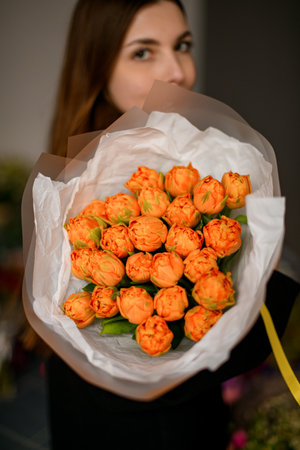 Cute woman holding a bouquet of orange rosesの写真素材
