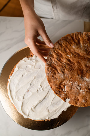 Whipping cream for cake delight. The hands of a skilled chef