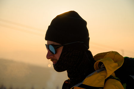 Portrait of Skier in protective glasses, balaclava, against blurred winter forest backgroundの写真素材