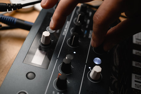 Close up top view of male hand turning two fingers knob on music recording controller