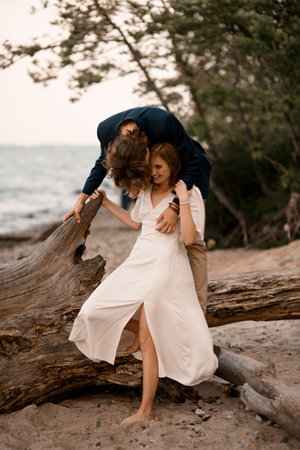 Husband stands behind his wife and bends down to kiss her faceの写真素材