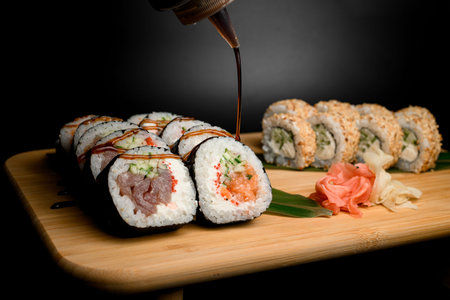 Watering with soy sauce assorted sushi sets on a wooden big boardの写真素材