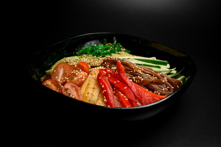 Salad of sweet red pepper, cucumbers, avocado, seaweed with sesame seeds on a plateの写真素材
