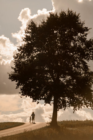 girl with longboard, beckoning, poised for adventure.の写真素材