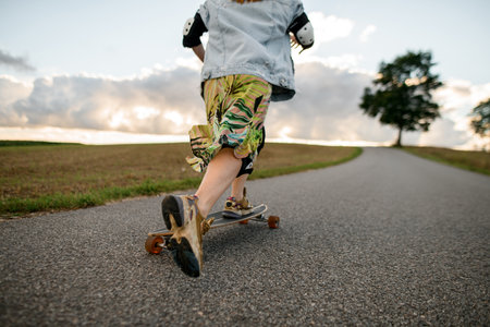 Cloudy cruise. Girl on longboard rides, viewed from the rear.の写真素材