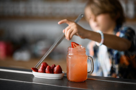 Focus on a glass jar with a handle that is filled with a pink cocktailの写真素材