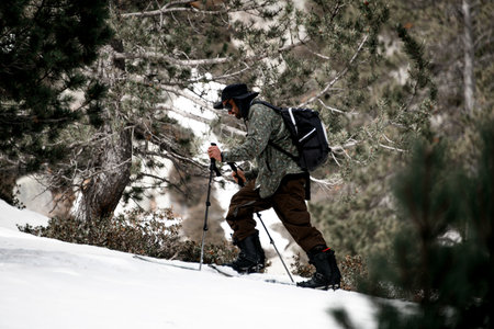 Close-up of a young skier confidently moving down the slope diligently rearranging his ski polesの写真素材