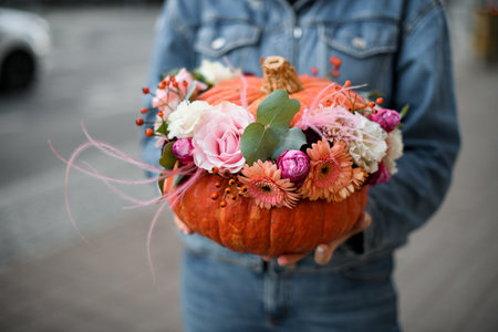 Beautiful flower arrangement decorated with a pumpkin for the holiday of Halloweenの写真素材