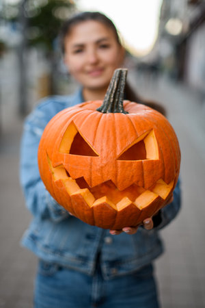 Close-up of a scary Halloween pumpkin with a carved mouth and eyesの写真素材