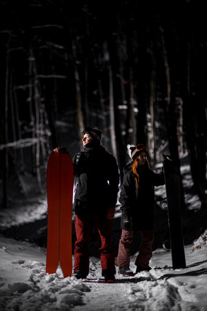 Male snowboarder holds a splitboard next to him and a woman holds a snowboardの写真素材
