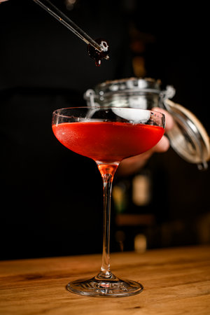 Close-up photo of a stemmed wine glass filled with a brown cold cocktailの写真素材