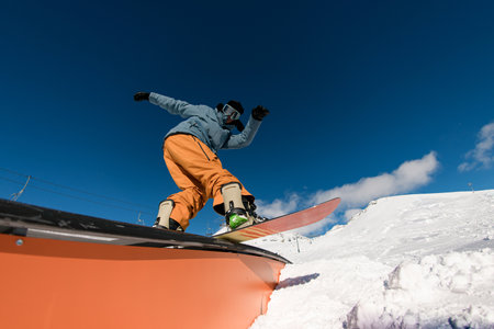 Expert snowboarder balancing and executing tricks on the wallride.の写真素材