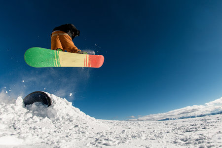 Jumping snowboarder. Springboard launch adds thrill to the descent.の写真素材