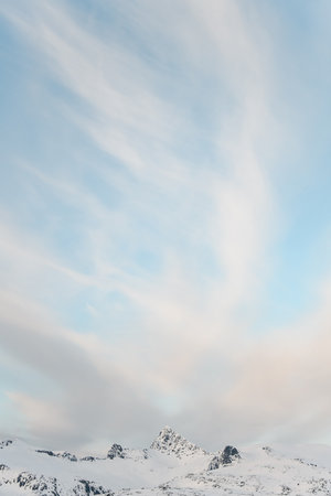 Beautiful photo of a blue sky with white striped clouds. Beautiful winter mountain landscapeの写真素材