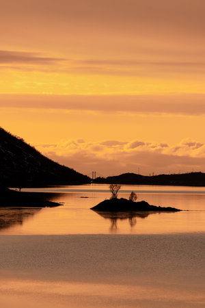 Sunset in the mountains, between which there is a small river with small islands of rockの写真素材
