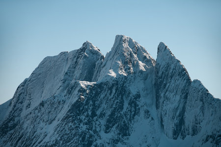 Close-up of towering mountains with sharp peaks. The rocks are covered with snowの写真素材