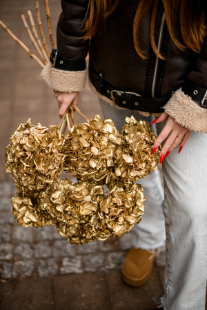 Female hands holding a bouquet of dry golden hydrangeasの写真素材