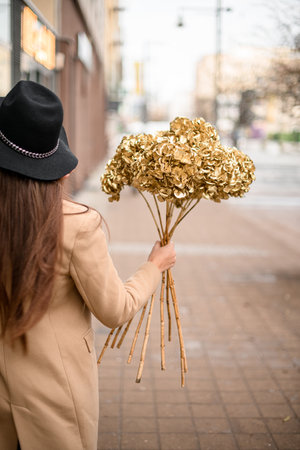 Young woman holding a bouquet of dry golden hydrangeasの写真素材